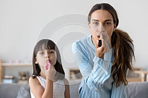 Funny kid girl applying lipstick doing makeup copying mom, portr