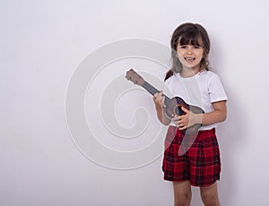 Funny kid girl with guitar, ukulele guitar.