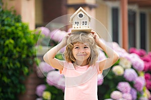 Funny kid hold toy little house. Child making a new dream home. Family home dream. Adorable child with toy wooden house