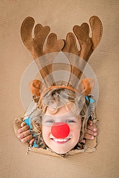 Funny kid looking through hole on cardboard