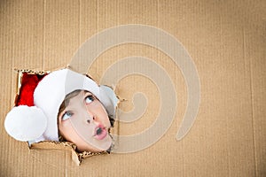 Funny kid looking through hole on cardboard