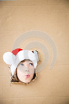 Funny kid looking through hole on cardboard