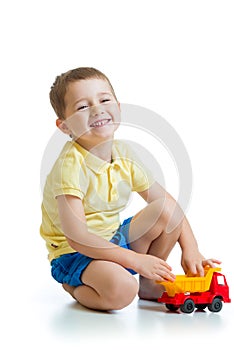 Funny kid playing with lorry toy isolated on white