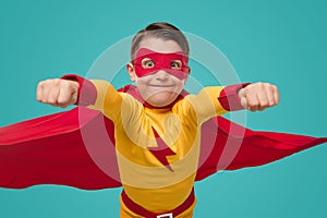 Funny kid in superhero costume with fists up