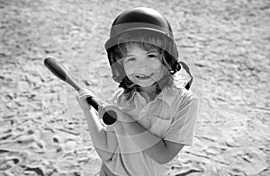 Funny kid up to bat at a baseball game. Close up child portrait.