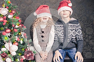 Funny kids at Christmas holiday near decorated christmas tree