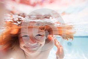 Funny kids face under water. Child swim and dive underwater in the swimming pool. Summer vacation.