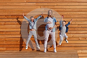 Funny kids jump. happy pregnant woman and two sons. pregnancy photo