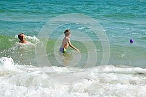 Funny kids playing in sea. The boys splashing in sea water. Family vacation in the tropics. Children play in ocean.