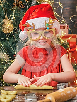 Funny kids are preparing the dough playing with flour in the kitchen. Funny child girl are preparing gingerbread for