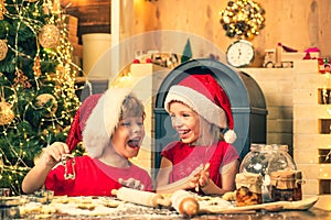 Funny kids are preparing the dough playing with flour in the kitchen. Funny Kids in kitchen making christmas cookies.