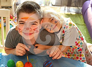 Funny kids with stained faces having fun at home in the kitchen. Brother and little sister. Funny. Creative concept. Mess at home