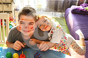 Funny kids with stained faces having fun at home in the kitchen. Brother and little sister. Funny. Creative concept. Mess at home