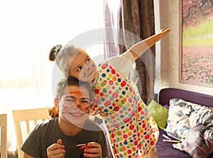 Funny kids with stained faces having fun at home in the kitchen. Brother and little sister. Funny. Creative concept. Mess at home
