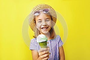 Funny laughing caucasian child girl with ice cream, close-up shot on yellow isolated background.