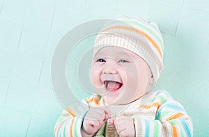 Funny laughing girl in a knitted sweater and hat o