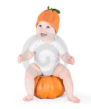 Funny laughing little baby on huge pumpkin