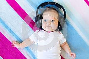 Funny laughing newborn baby listening ear phones