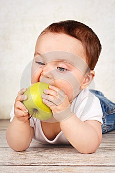 Funny little baby boy eating apple