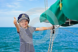 Funny little baby captain on board of sailing yacht