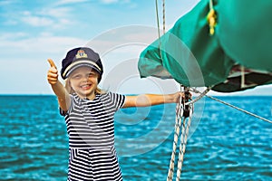 Funny little baby captain on board of sailing yacht