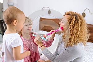 Funny little blond girl putting makeup on her mother`s face