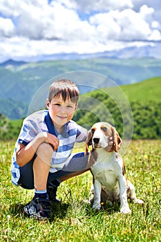 funny little boy with a dog in the mountains