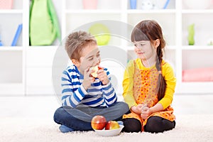 Funny little boy eating apple