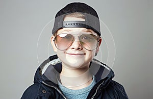 Funny little boy in glasses and cap. stylish smiling kid