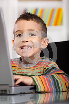 Funny little boy with laptop