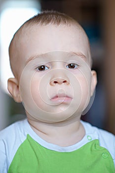 Funny little boy showing emotions, looking serious. Caucasian child 2 years old. Closeup portriat.