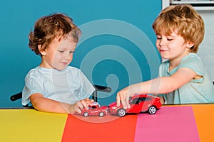 Funny little child having fun and play with toy car. Happy cute clever boy pupil at preschool. Cute child boy in