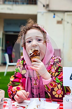 Funny little girl bites an ice cream