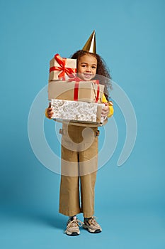 Funny little girl in cap holds birthday gift box