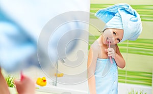 Funny little girl cleans teeth with toothbrush in bathroom