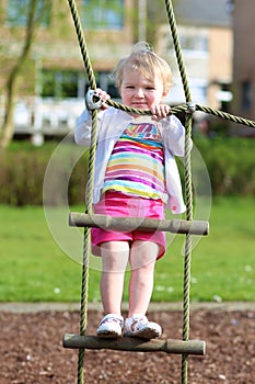 Funny little girl climbing in playground