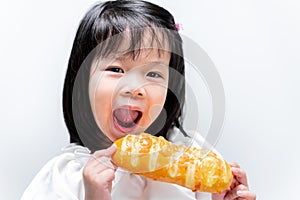 Funny little girl eating tasty bread with sweet jam. Child looking at camera. On isolated white background