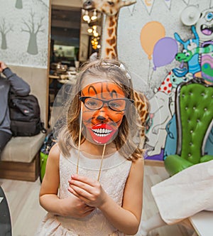 funny little girl with face painting at birthday party