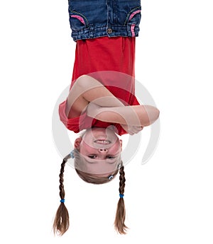 Funny little girl hanging upside down