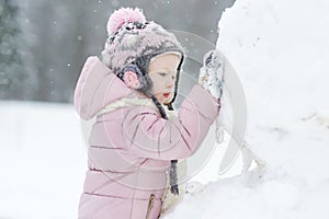 Funny little girl having fun in winter park