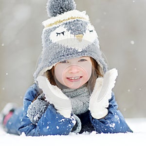 Funny little girl having fun in winter park