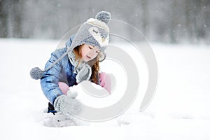 Funny little girl having fun in winter park