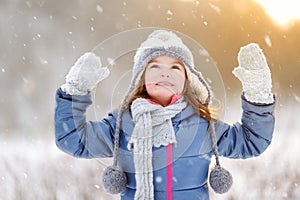 Funny little girl having fun in winter park