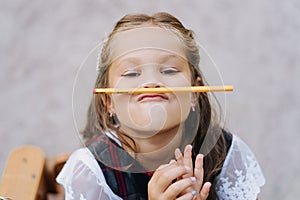 Funny Little Girl Hold Pencil On Lips Closeup