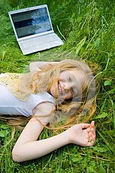 Funny little girl with laptop outside