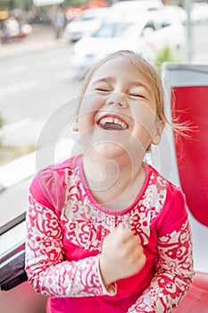 Funny little girl laughing out loud on bus