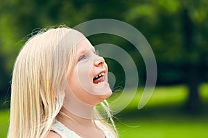 Funny little girl looking up and smiling