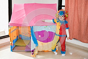 Funny little girl in multicolored clown wig costume