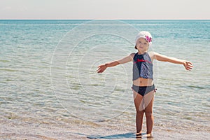 Funny little girl playing on the beach.