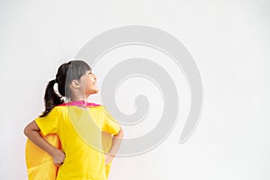 Funny little girl playing power superhero over white background. superhero concept